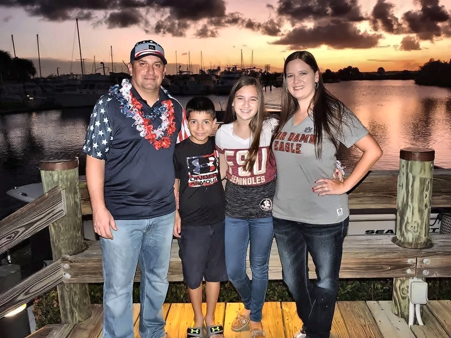 Family posing at sunset near a marina